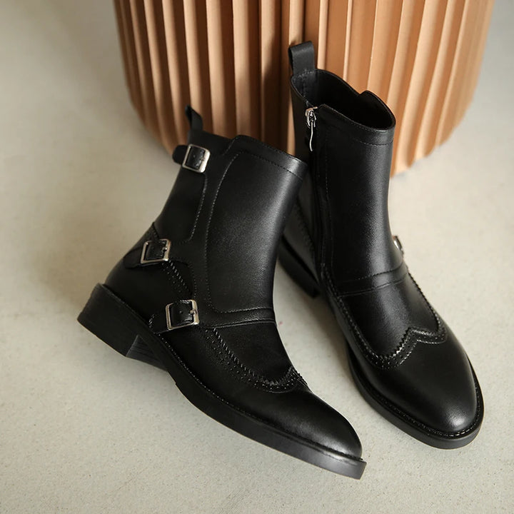 Pair of black leather Chelsea boots with triple buckle straps and brogue detailing