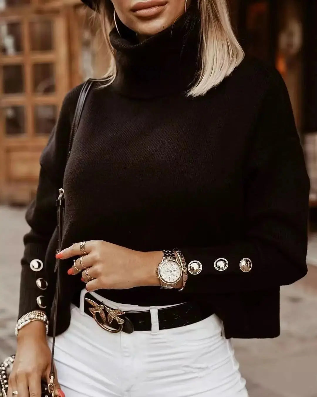 Close up of black ribbed turtleneck sweater with button cuff detail