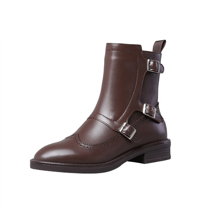 Brown leather Chelsea boot with buckle straps and brogue toe cap, studio shot