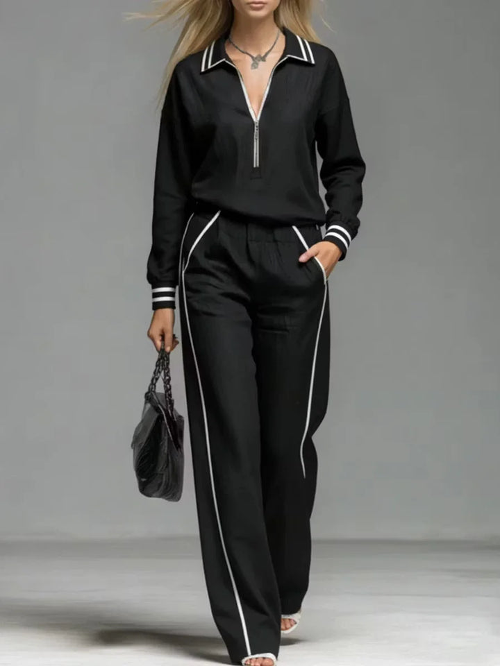 Woman wearing black half-zip two piece pant set close up