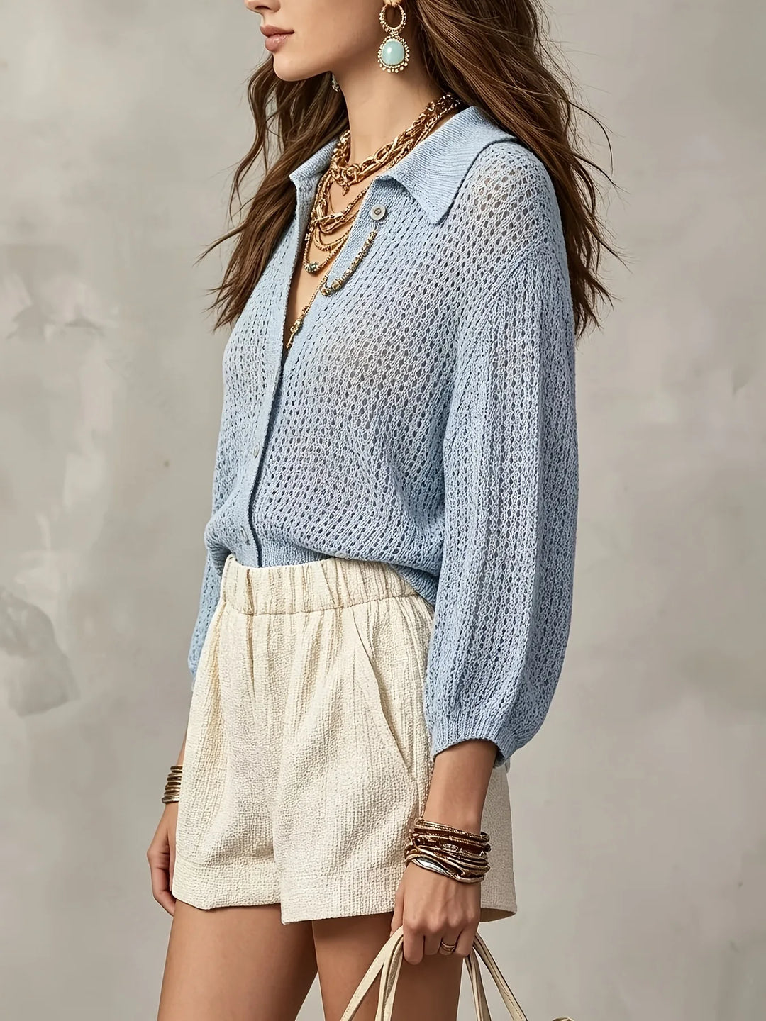 Side view of light blue open crochet knit cardigan with layered necklaces