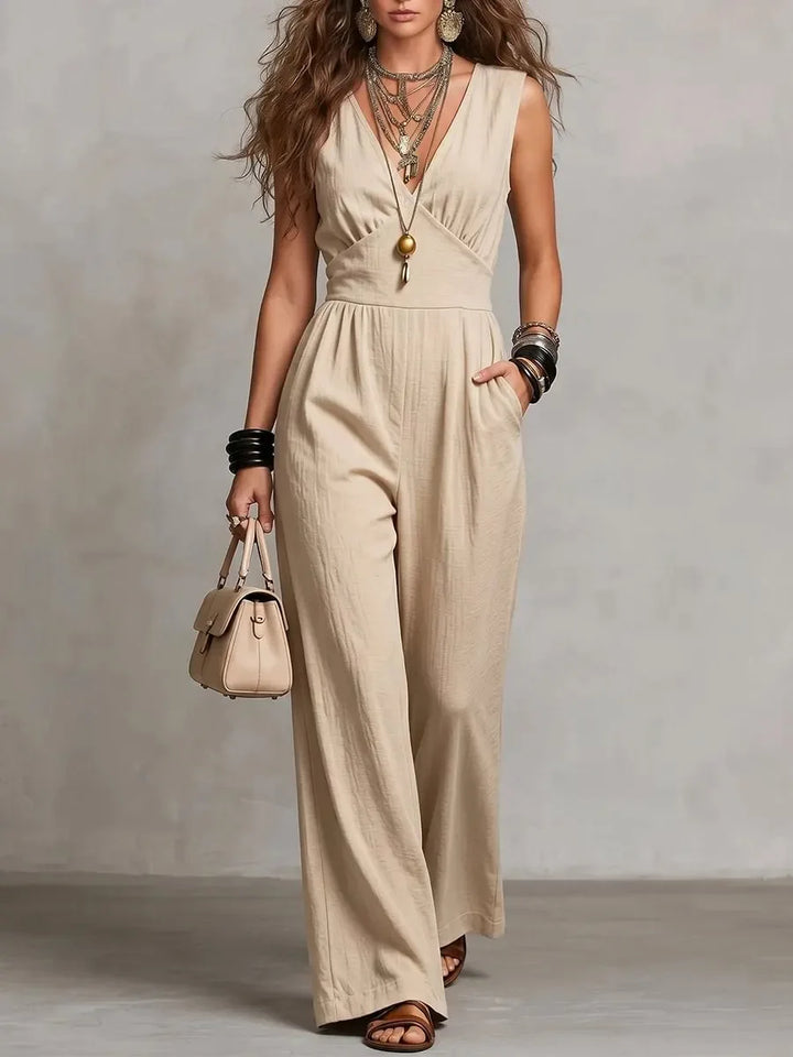 Woman wearing apricot wide leg jumpsuit with empire waist seam