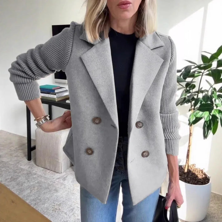 Woman wearing gray double-breasted blazer with ribbed knit sleeves