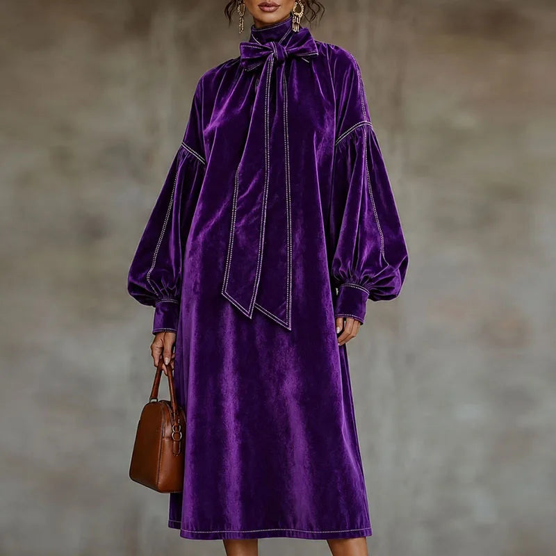 Woman wearing purple velvet maxi dress with bow tie collar