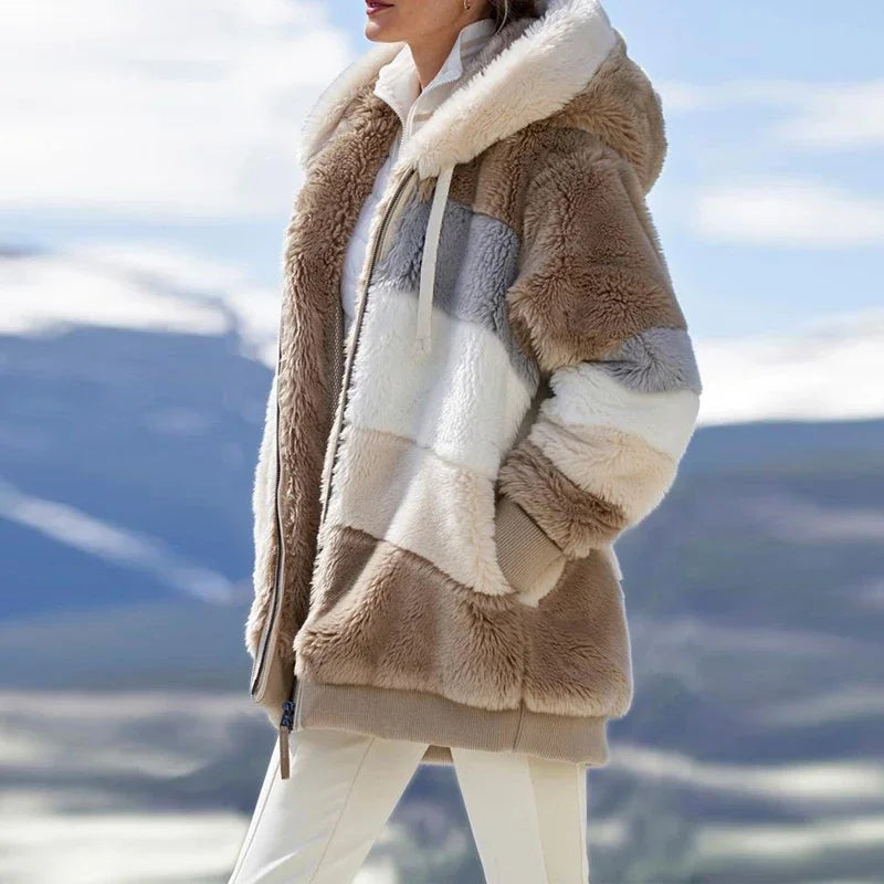 Woman wearing tan colorblock fleece hooded jacket with mountain backdrop