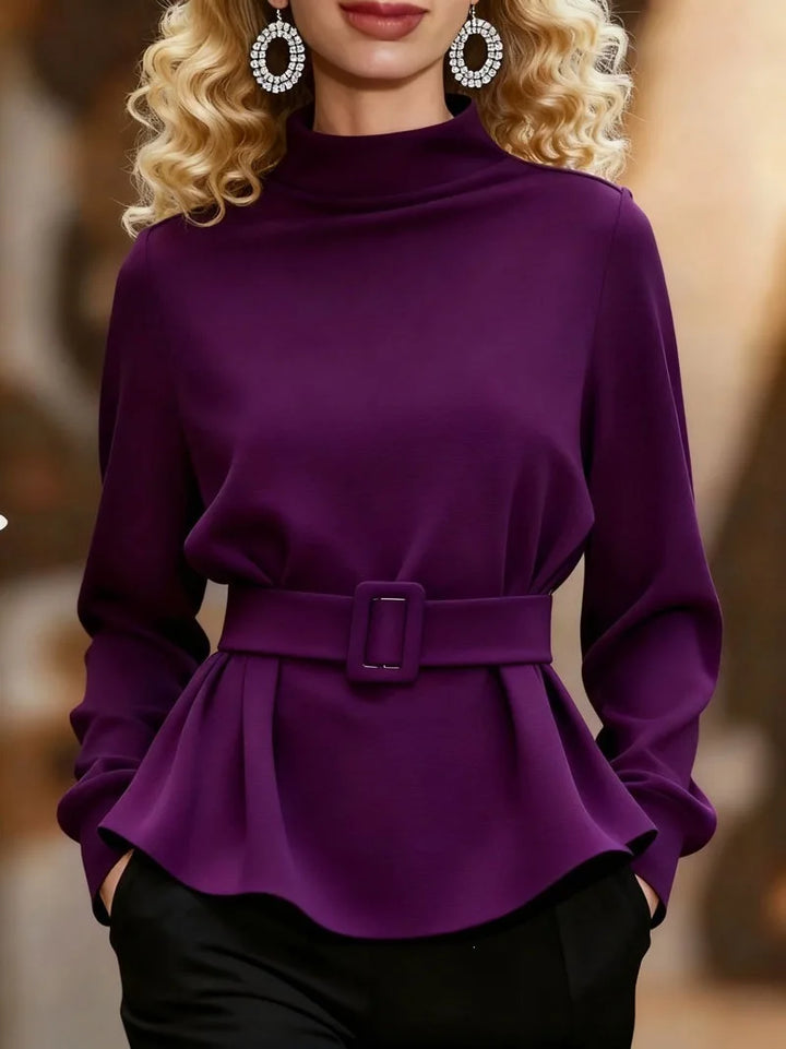 Purple belted peplum top with mock neckline, styled with earrings