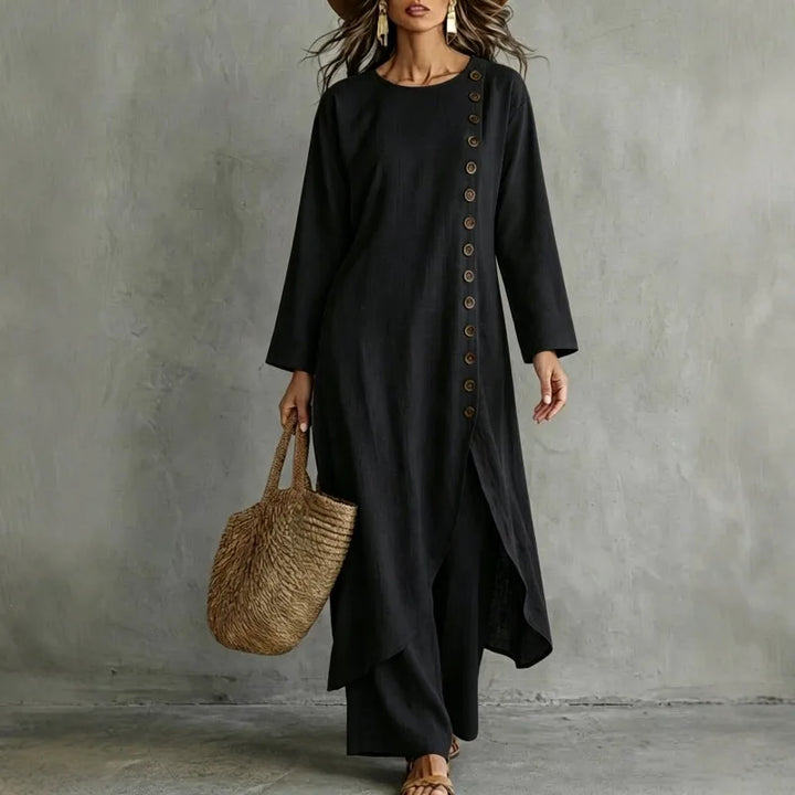 Woman wearing black two piece set with asymmetric button placket top and wide leg pants