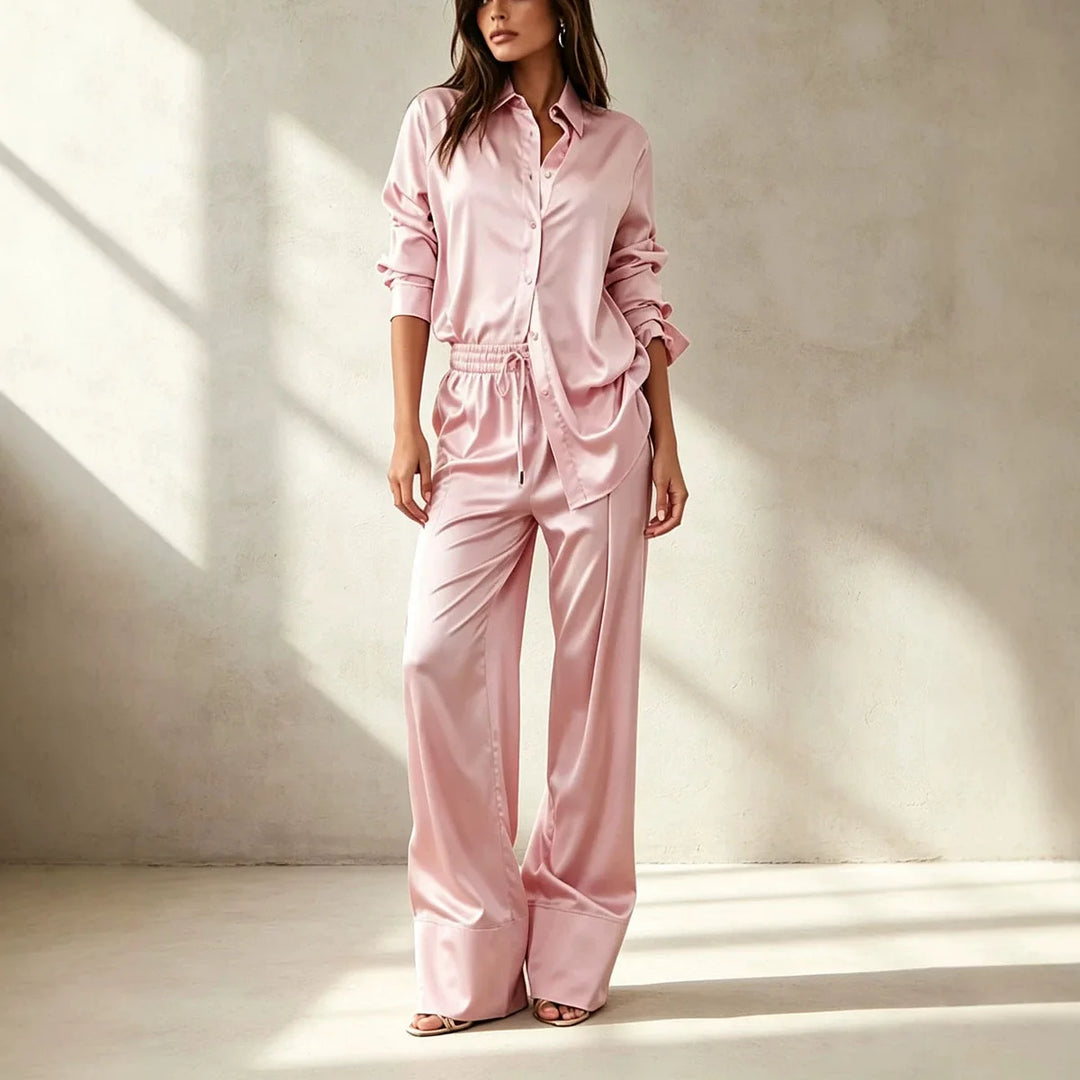 Woman wearing pink satin shirt and wide leg pant set, front view