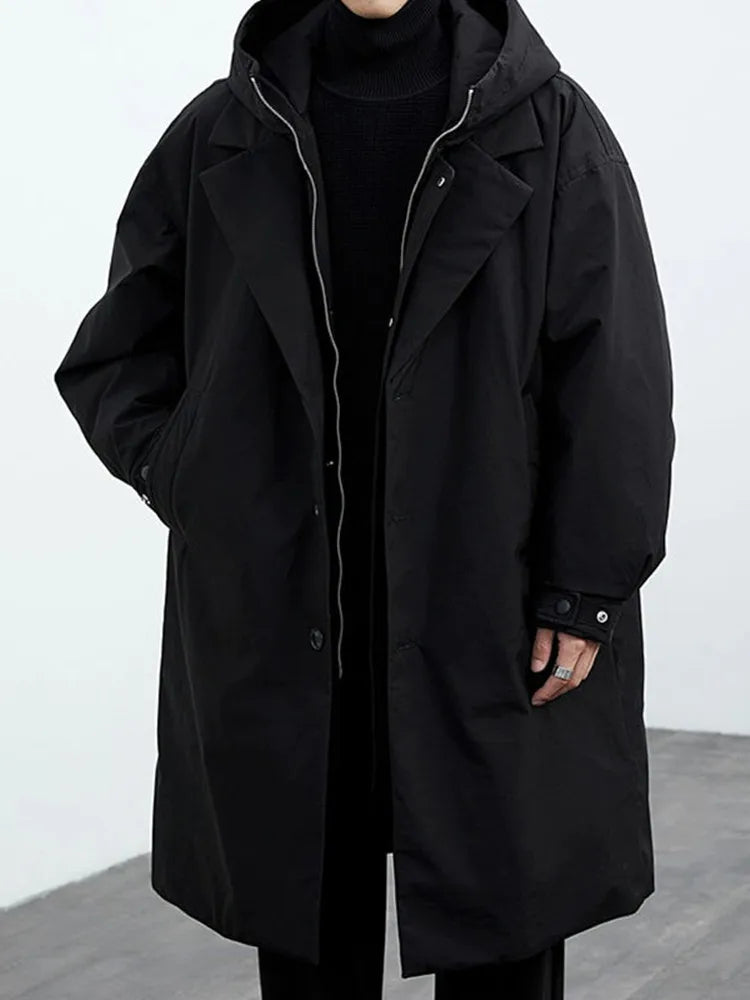 Man wearing black hooded trench coat, front view
