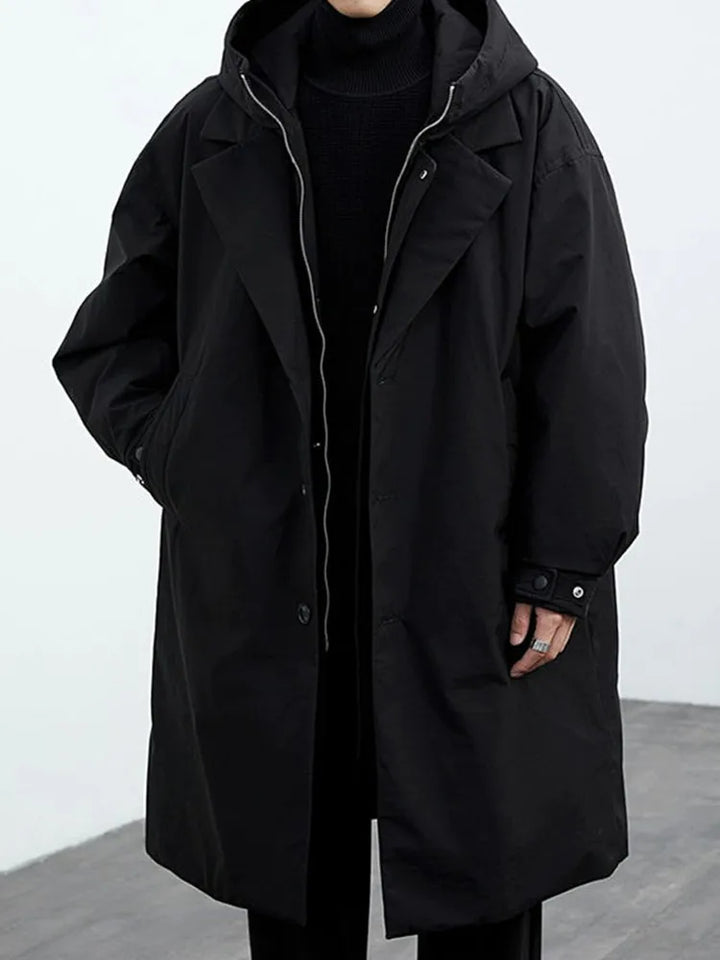 Man wearing black hooded trench coat, front view