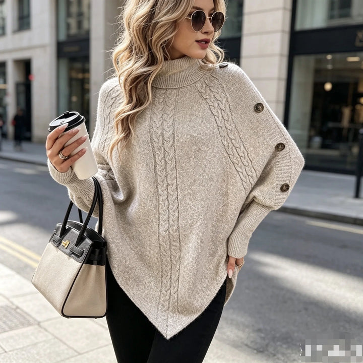 Woman wearing khaki cable knit poncho sweater with turtleneck, holding handbag
