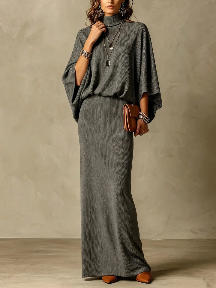 Woman wearing gray ribbed knit two piece skirt set with mock neck and batwing sleeves