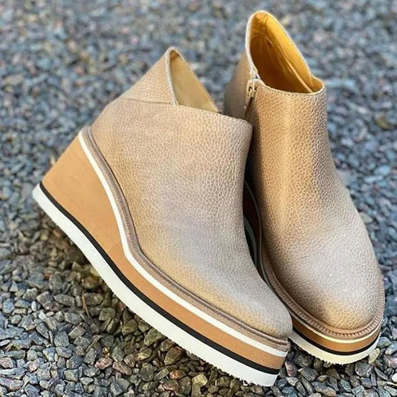Beige leather platform wedge ankle boots on gravel