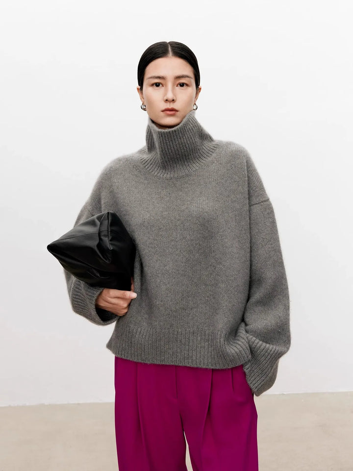 Woman wearing gray turtleneck sweater with magenta trousers