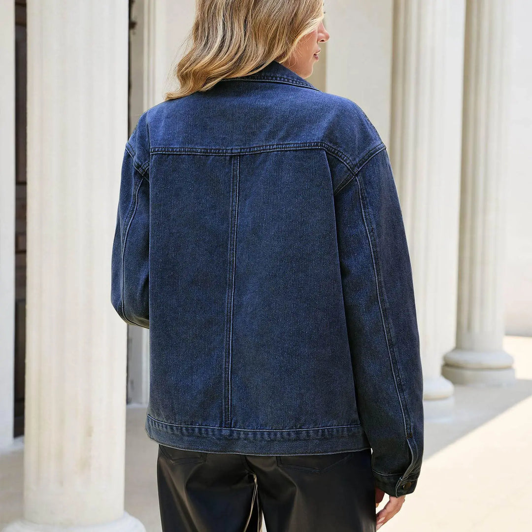 Back view of dark blue denim jacket on model outdoors