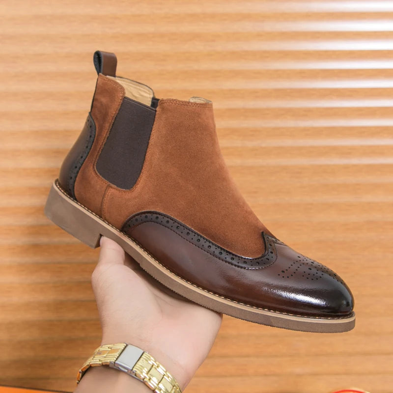 Brown suede and leather wingtip Chelsea boot held in hand