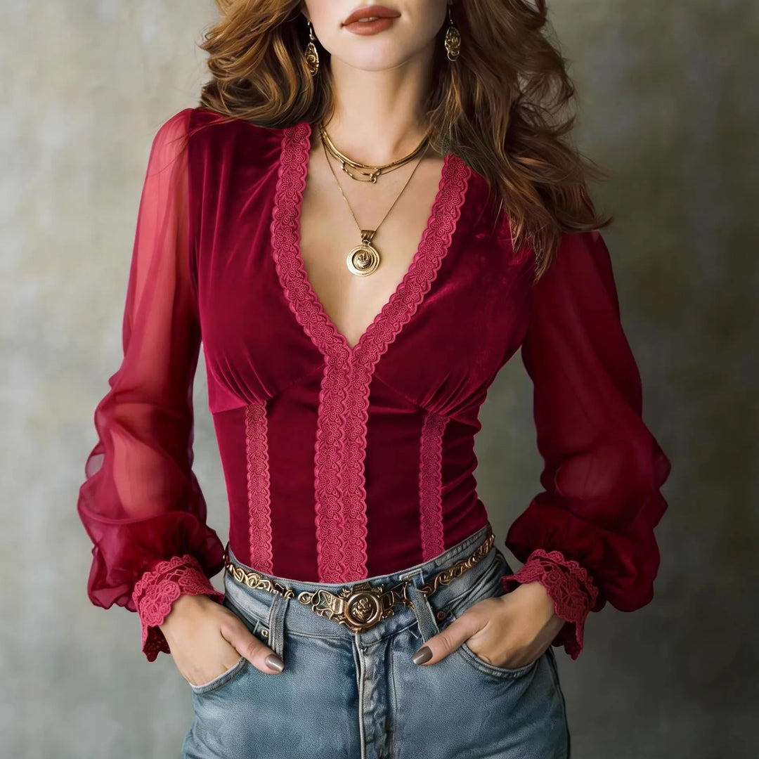 Woman wearing deep red velvet blouse with lace trim and sheer mesh sleeves