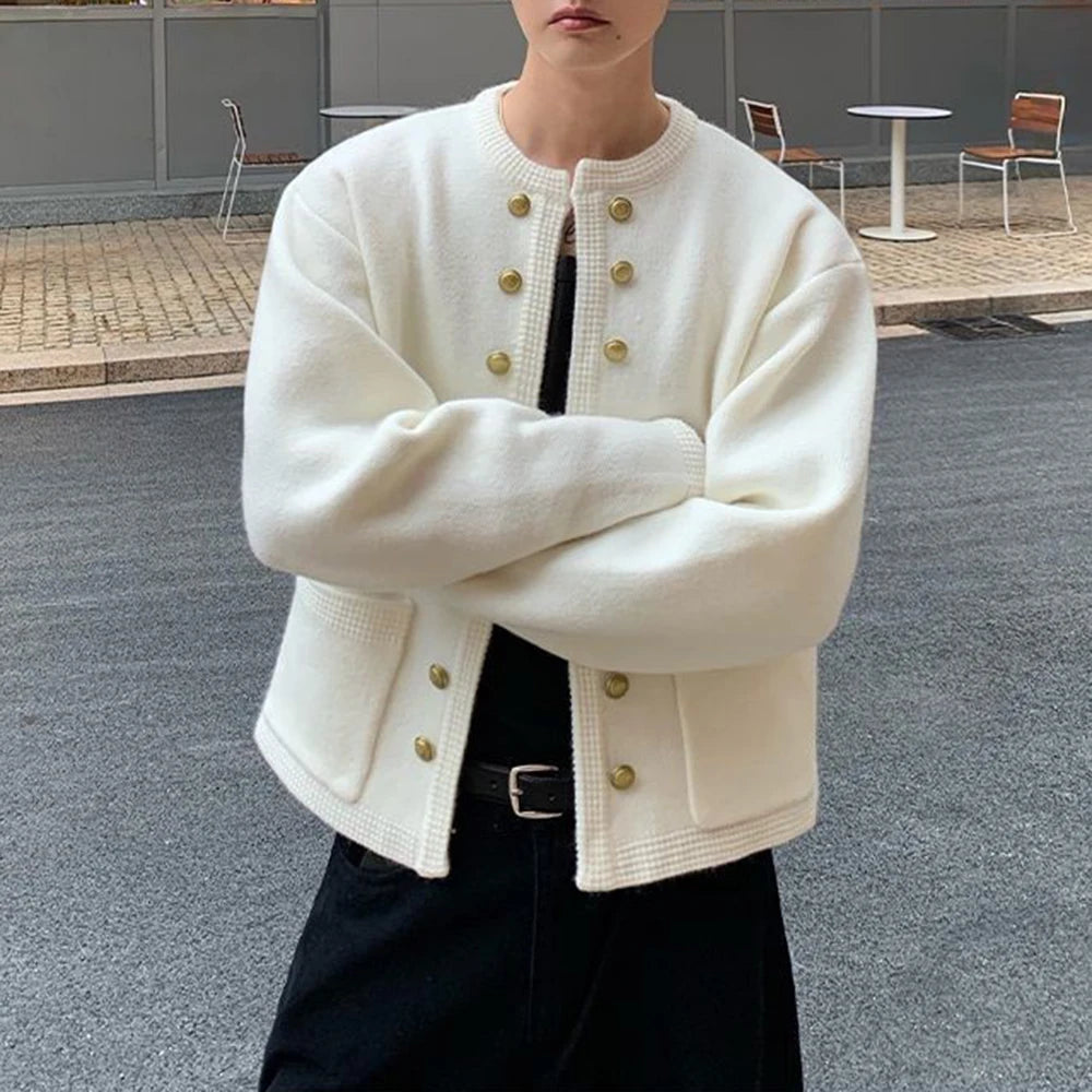 Man in white knit cardigan with arms crossed, detail view