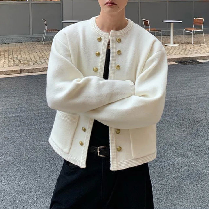 Man in white knit cardigan with arms crossed, detail view
