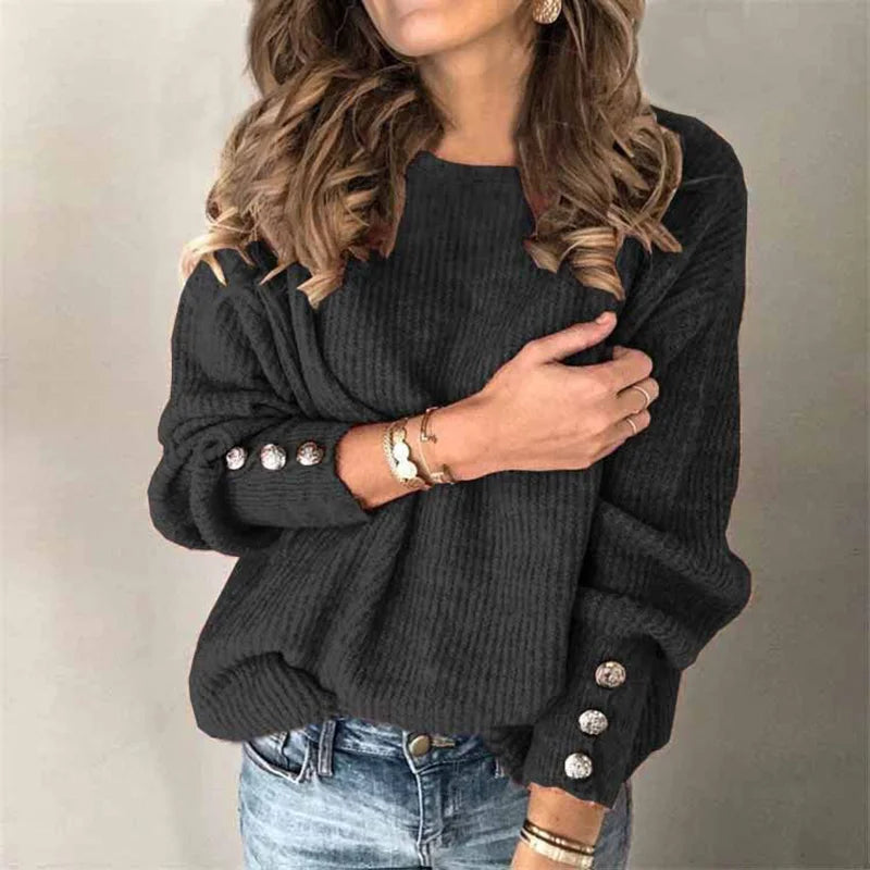 Woman wearing black ribbed knit sweater, close view of button cuff detail