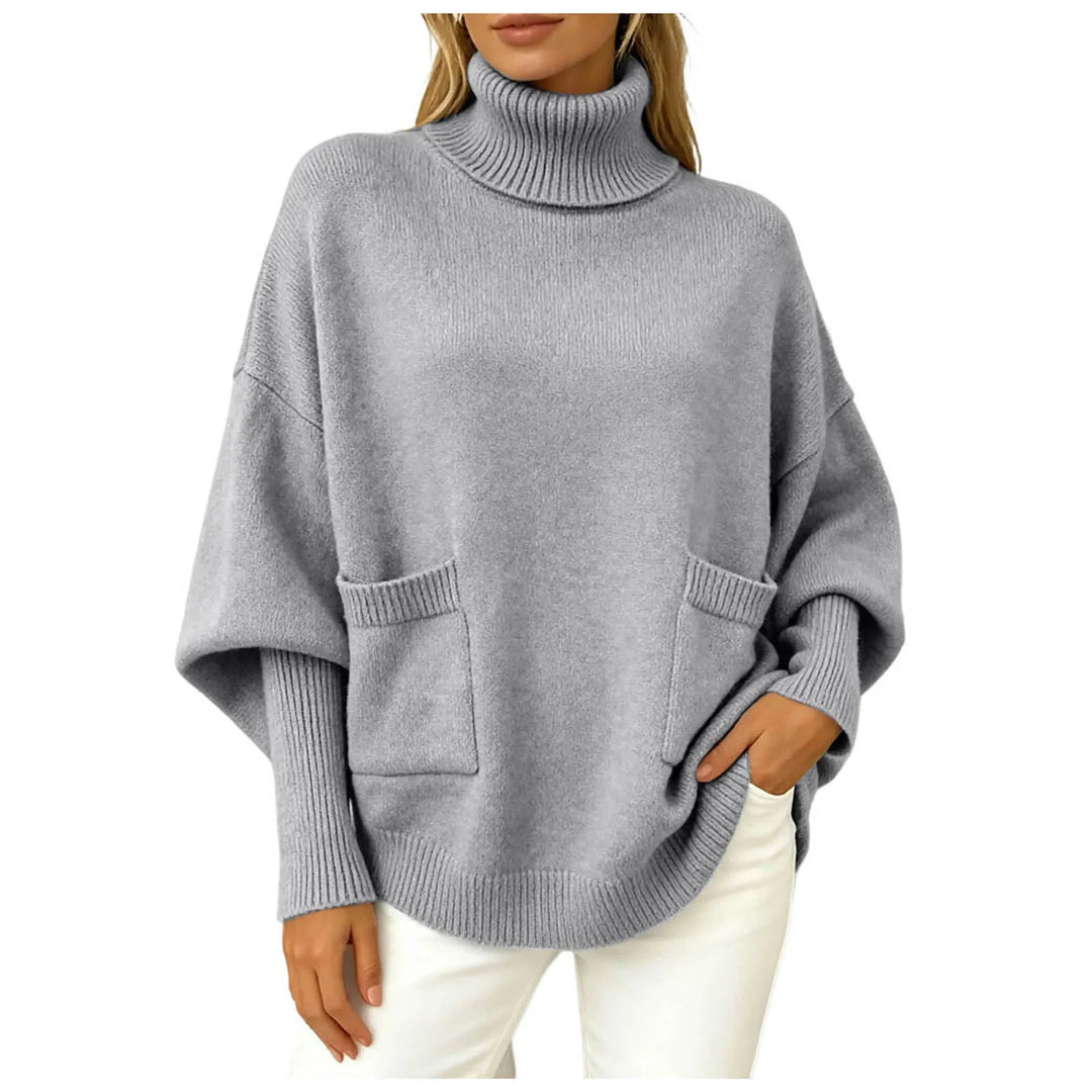 Woman wearing grey oversized turtleneck sweater with front pockets