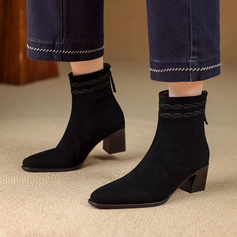 Woman wearing black suede ankle boots with braided collar detail