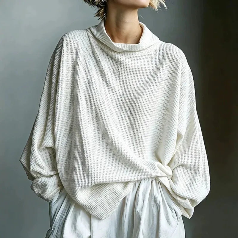 Woman wearing white waffle knit top with funnel collar, front view