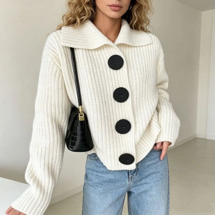 Woman wearing beige knit cardigan with black buttons and crossbody bag