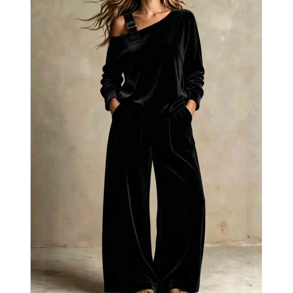 Woman wearing black velvet off shoulder top and wide leg pants set with buckle strap detail