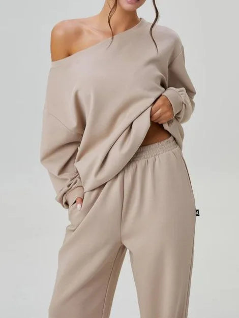 Close up of apricot off-shoulder sweatshirt with hand in pants pocket
