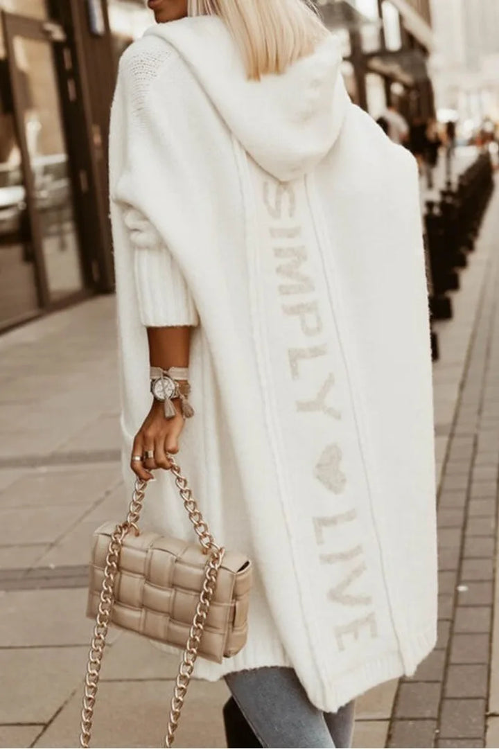 Back view of white cardigan showing knit lettering detail