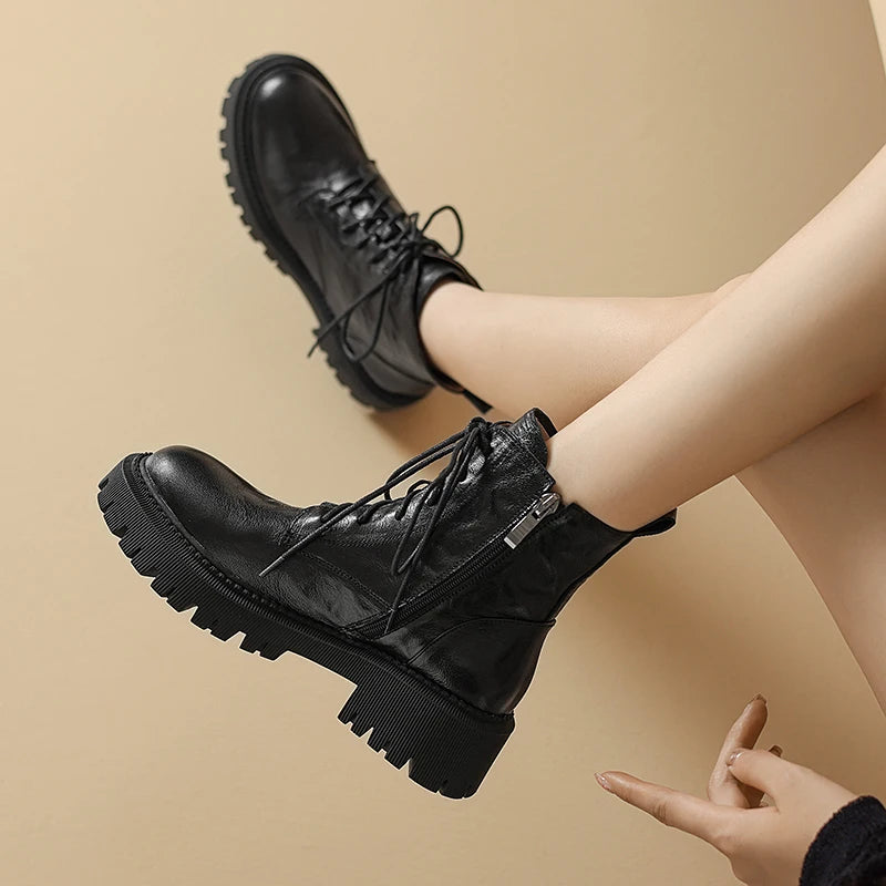 Model with legs crossed wearing black ankle boots