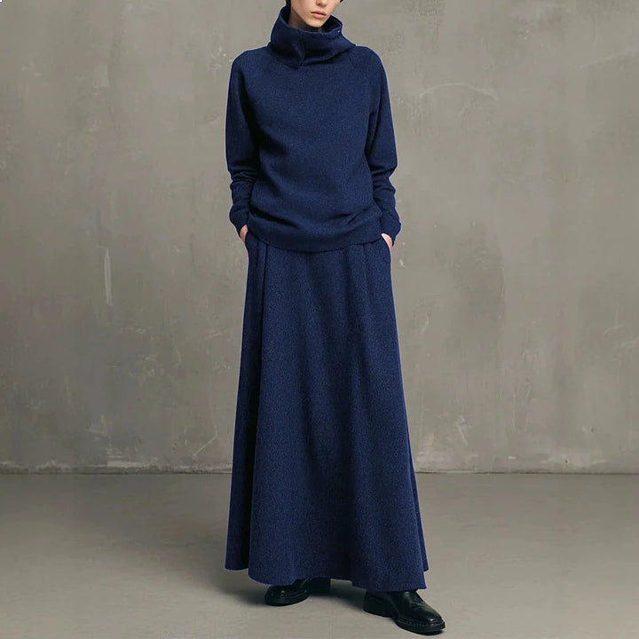 Woman wearing navy blue funnel neck sweatshirt and matching maxi skirt set