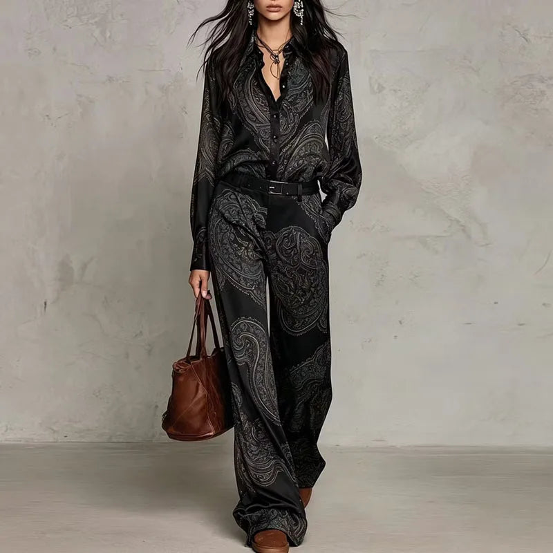 Woman wearing black paisley print two-piece shirt and wide leg pants set with belt
