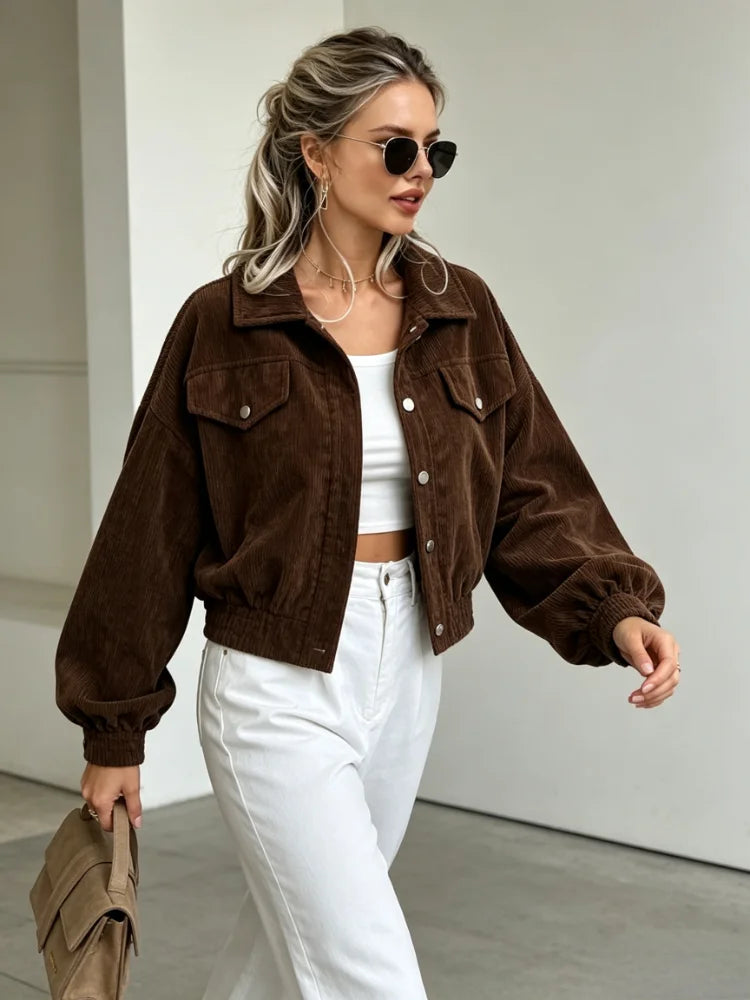 Woman walking in brown corduroy jacket and white jeans