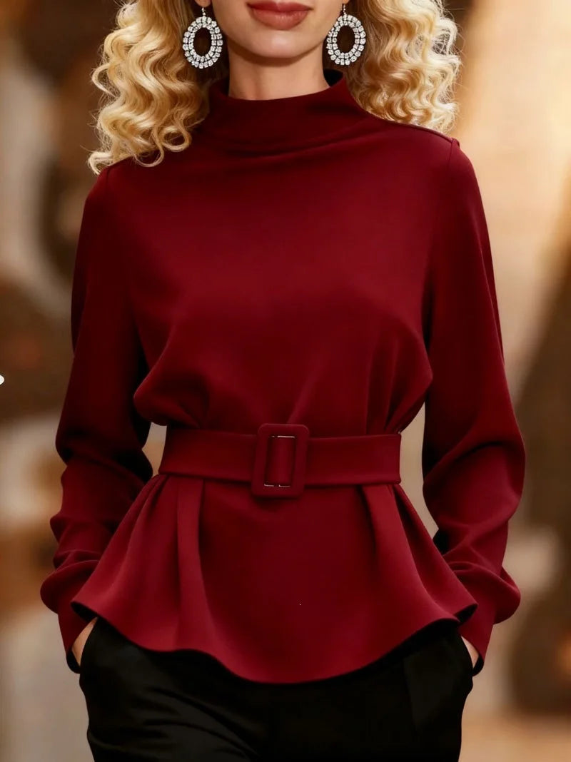 Red belted peplum top with mock neckline, styled with earrings
