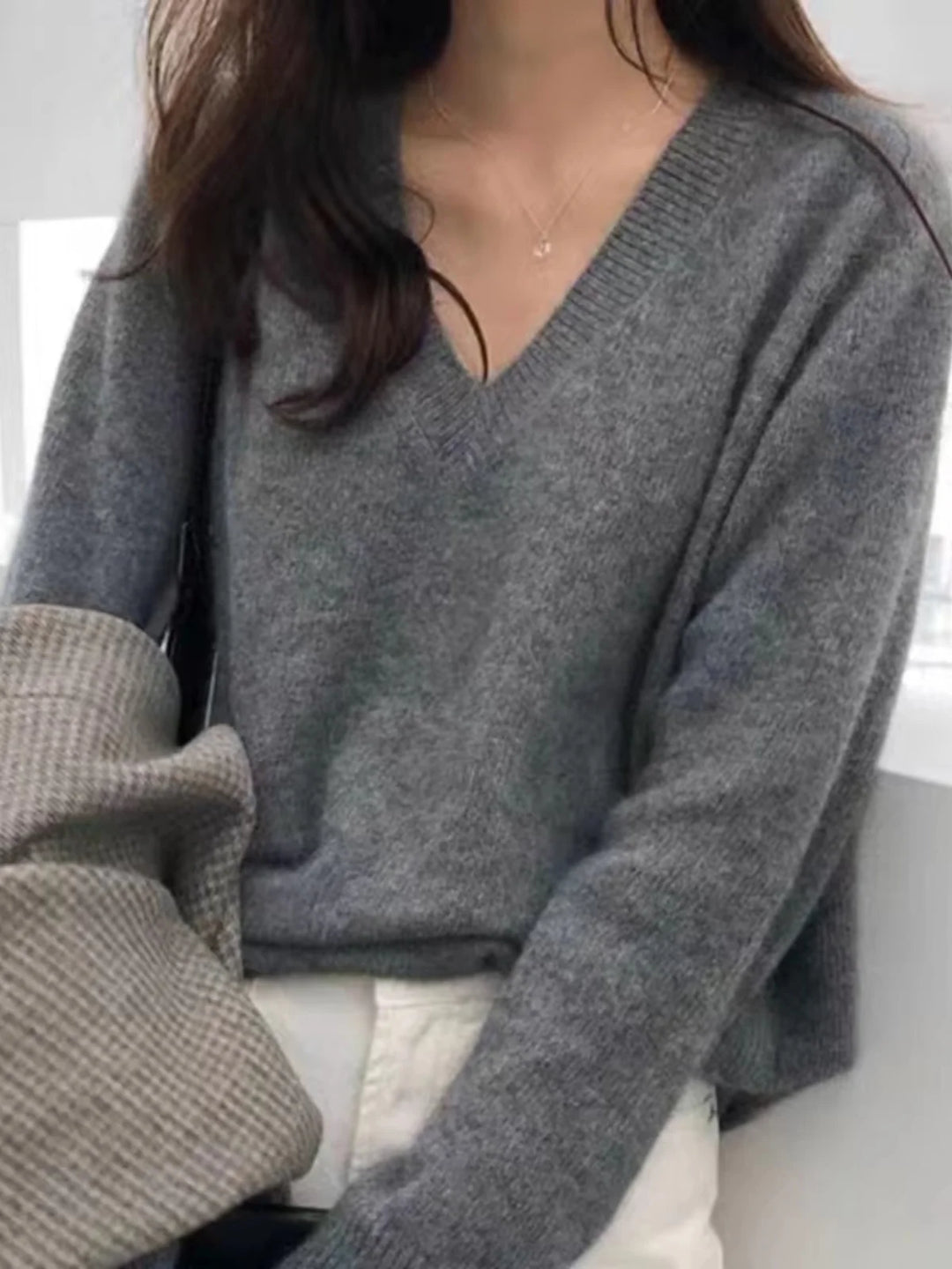 Close up of gray V-neck sweater with ribbed trim