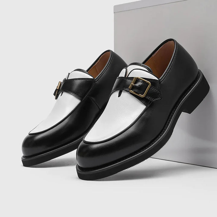 Black and white two-tone leather loafers with buckle strap, studio shot