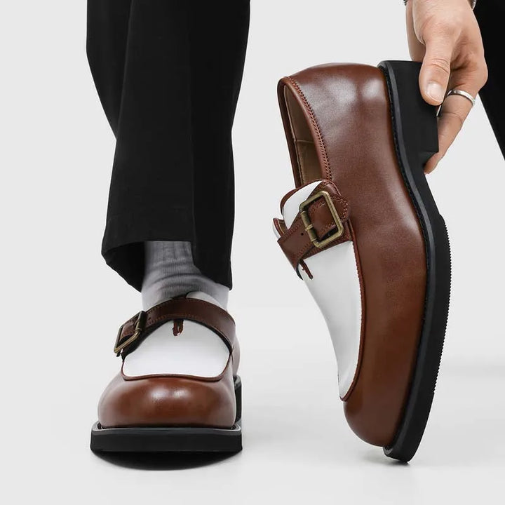 Man holding brown and white two-tone loafer with buckle detail