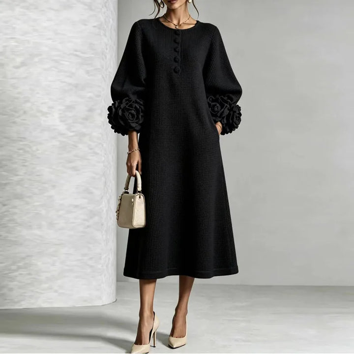 Woman wearing black knit midi dress with floral cuffs