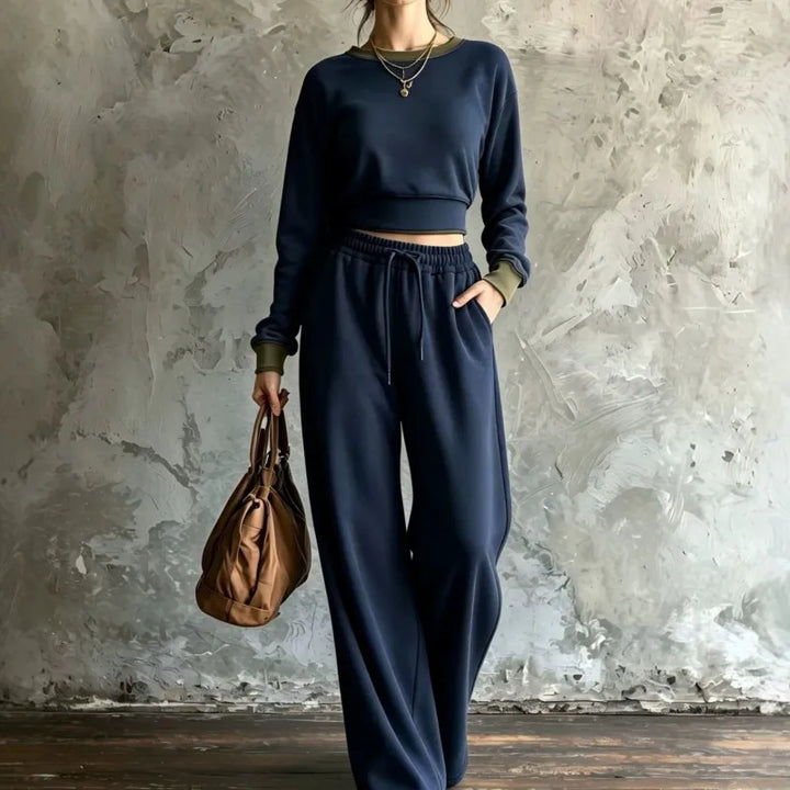 Woman wearing navy blue cropped sweatshirt and wide leg pants set with olive trim