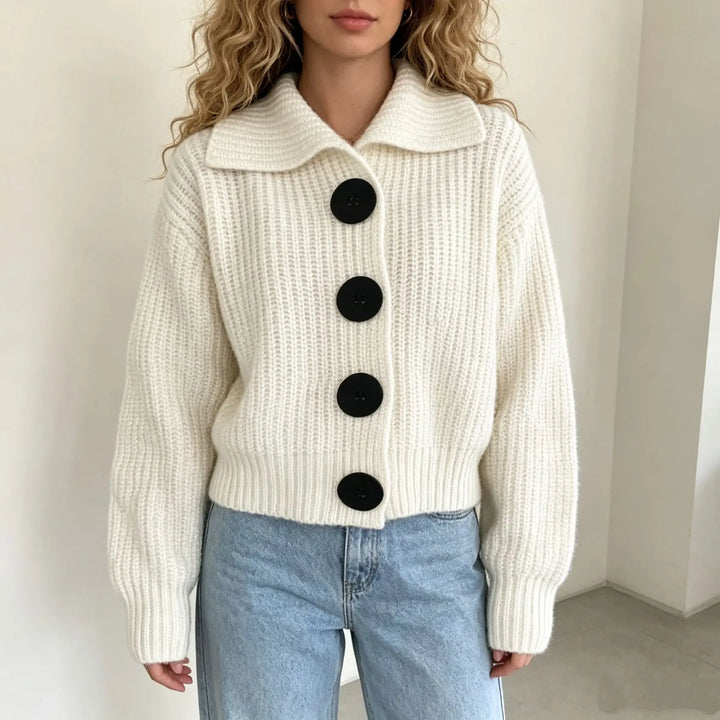 Woman wearing ivory ribbed knit cardigan with black buttons and collar