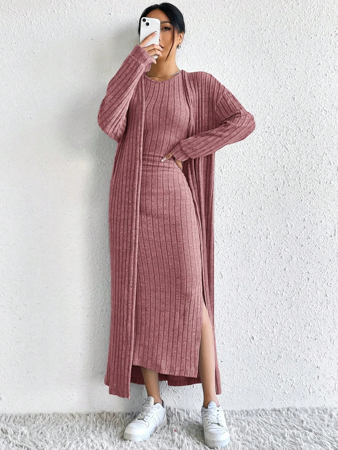 Woman taking mirror selfie in pink ribbed dress and cardigan set