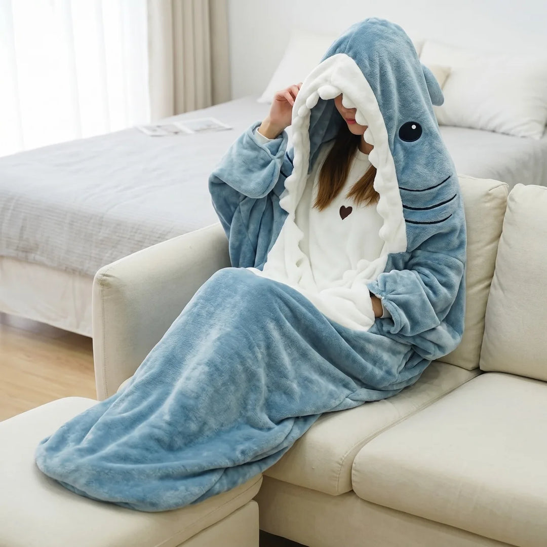 Person wearing blue shark wearable blanket on sofa