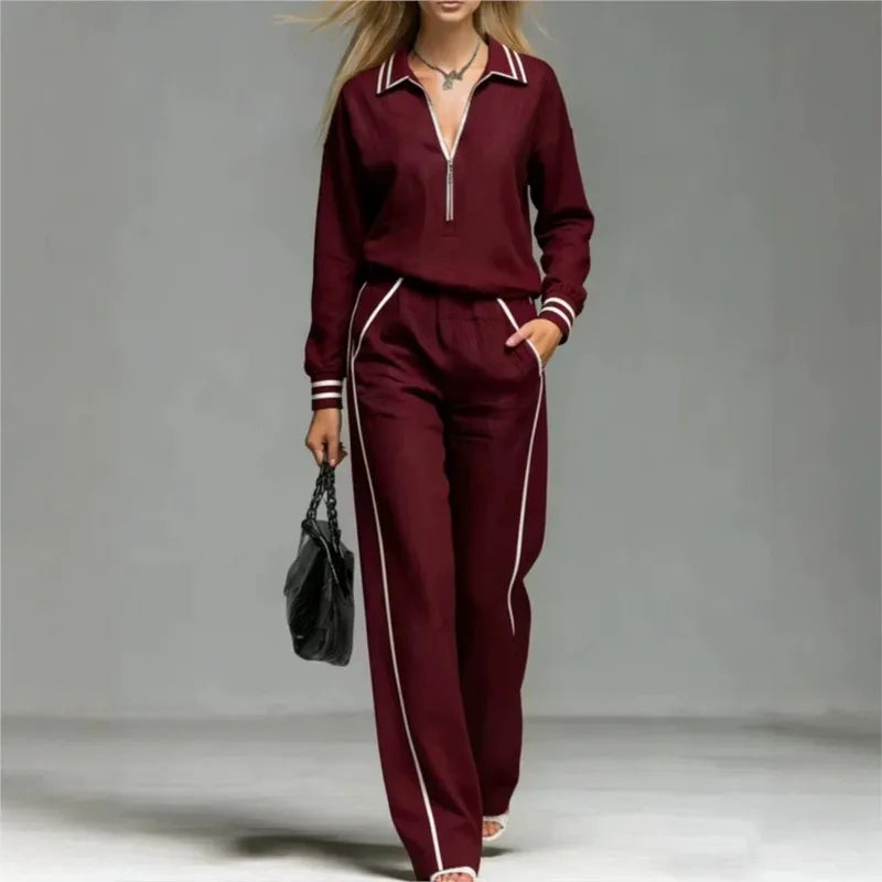 Woman wearing burgundy half-zip two piece pant set with contrast stripe trim