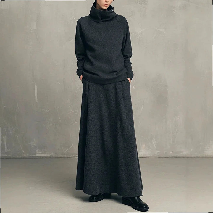Woman wearing charcoal grey funnel neck sweatshirt and matching maxi skirt set