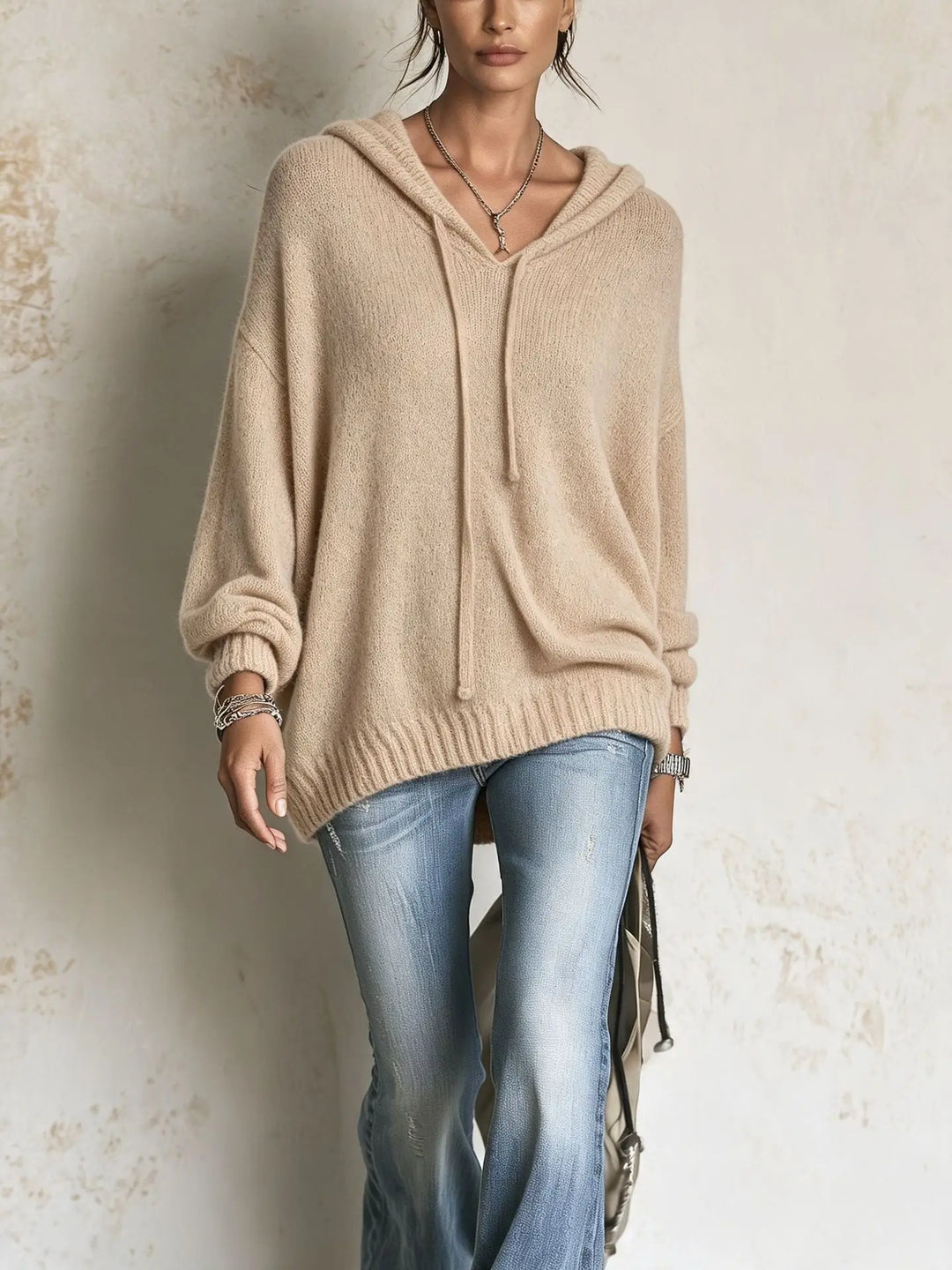 Woman wearing khaki hooded knit sweater with high low hem