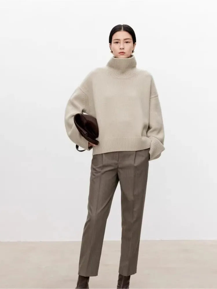 Beige turtleneck sweater styled with brown trousers and boots