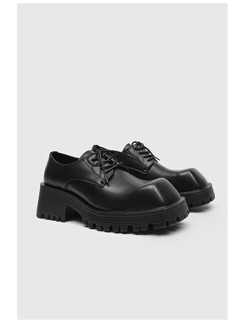 Pair of black chunky derby shoes on white background