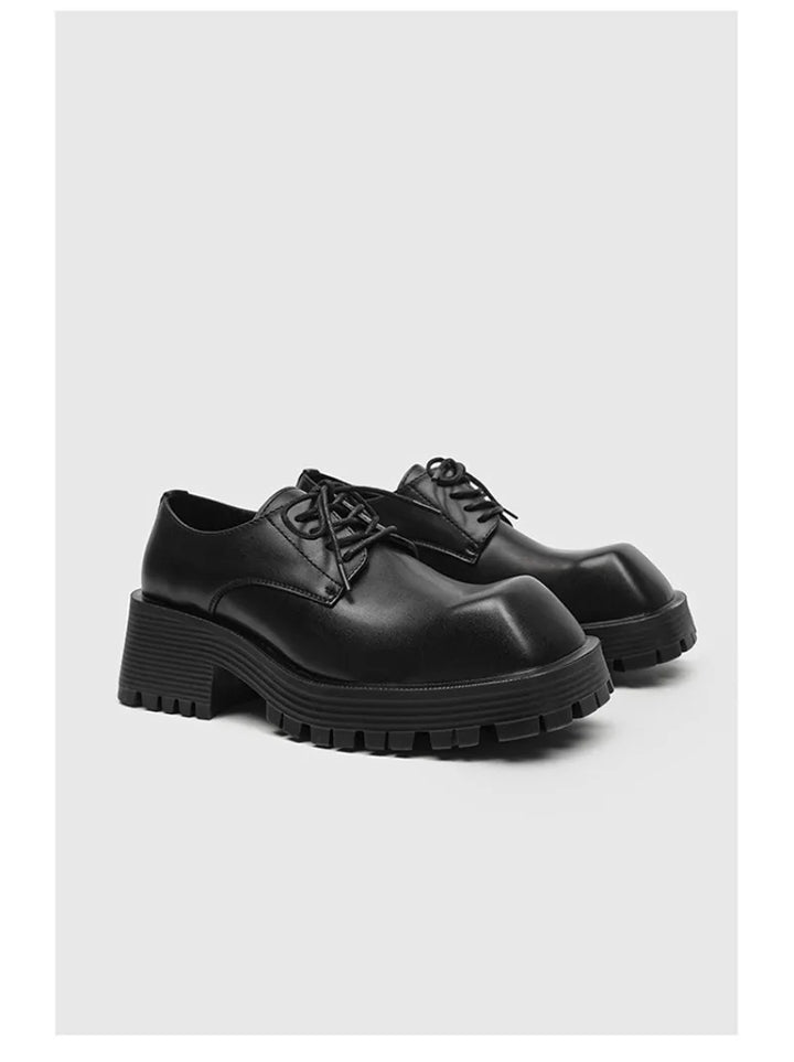 Pair of black chunky derby shoes on white background